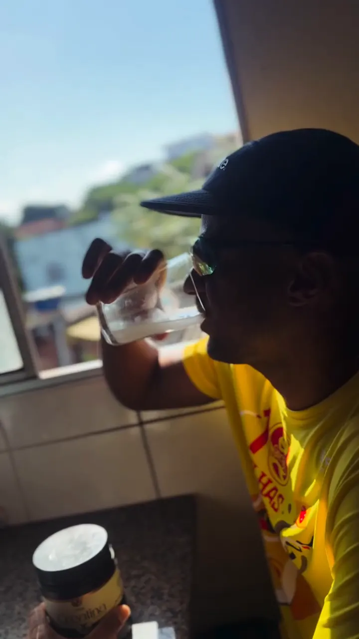Atleta com a camiseta da Dez Milhas tomando a creatina UniMax, com o pote em primeiro plano