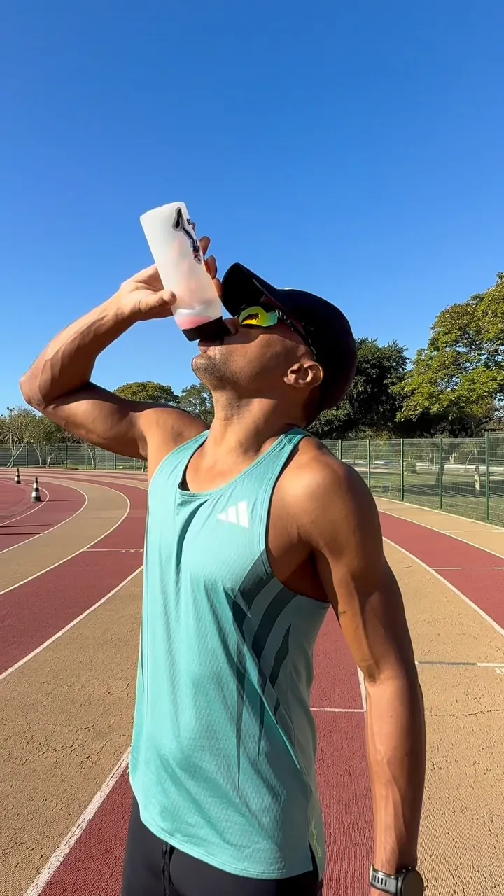 Atleta se hidratando na pista de atletismo